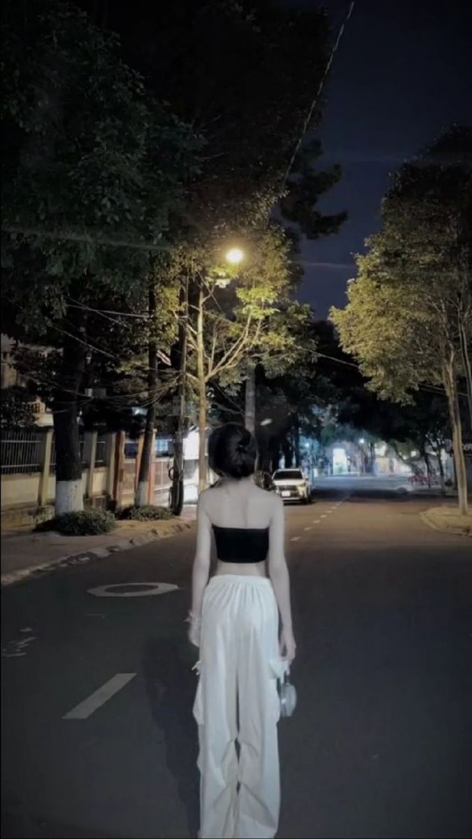 Gái trẻ mặc áo crop top đen và quần trắng trên phố vàng