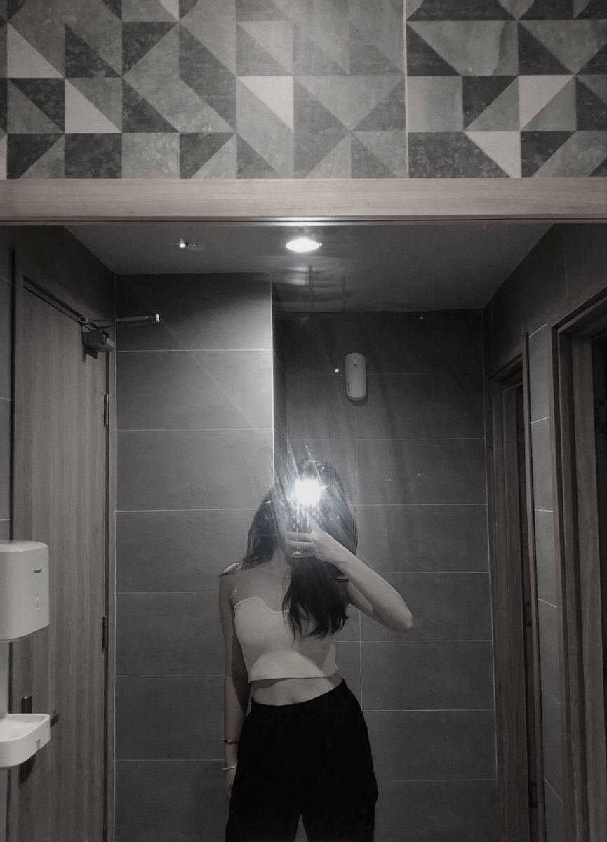 Gái trẻ mặc áo croptop trắng và quần đen chụp ảnh trong gương