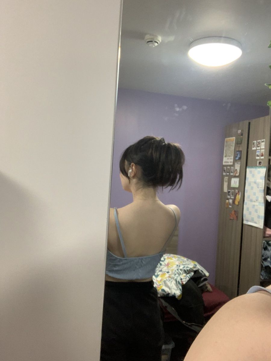 Gái trẻ mặc áo hai dây và quần shorts trong phòng ngủ