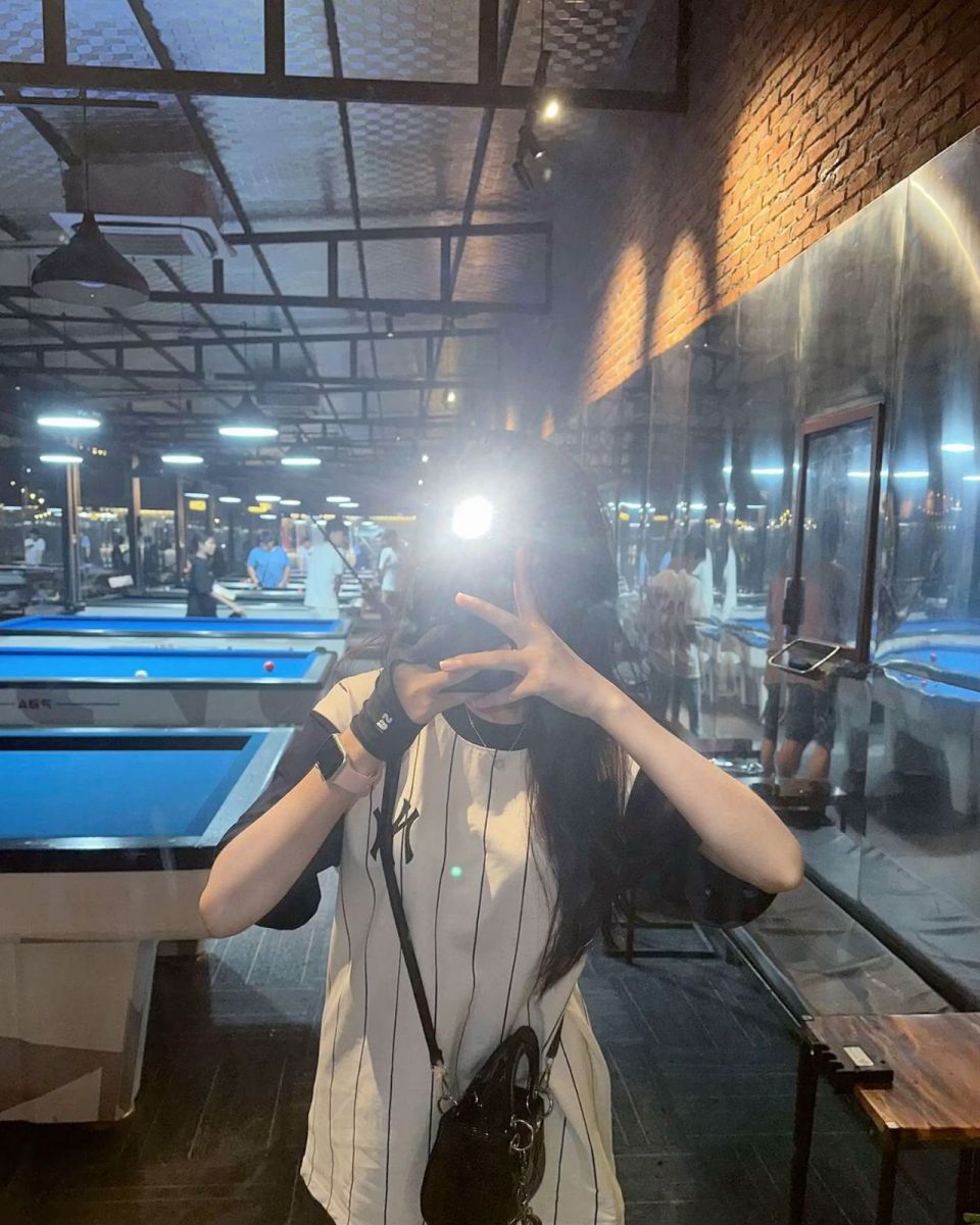 Gái trẻ mặc áo thun kẻ sọc đen trắng chụp ảnh selfie tại quán billiards