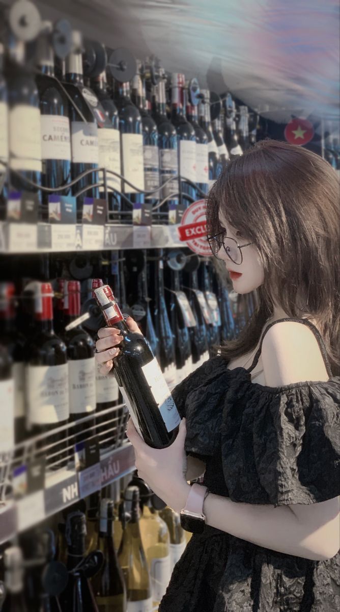 Gái xinh mặc áo blouse đen xòe dáng cảm chái rượu vang