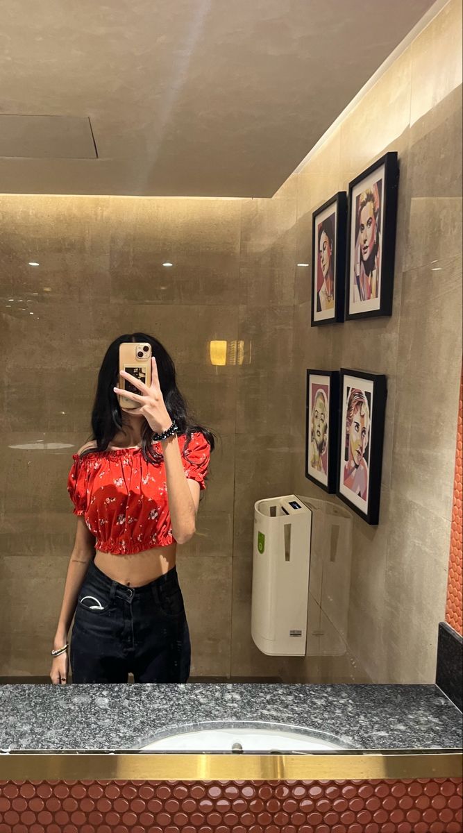 Gái xinh mặc áo crop top đỏ và quần jeans đen chụp hình selfie