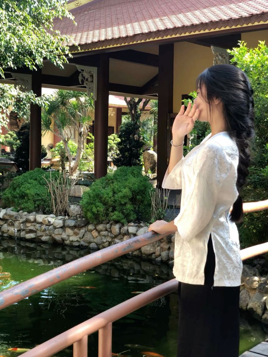 Gái xinh mặc áo dài trắng bên hồ cá tay vịn