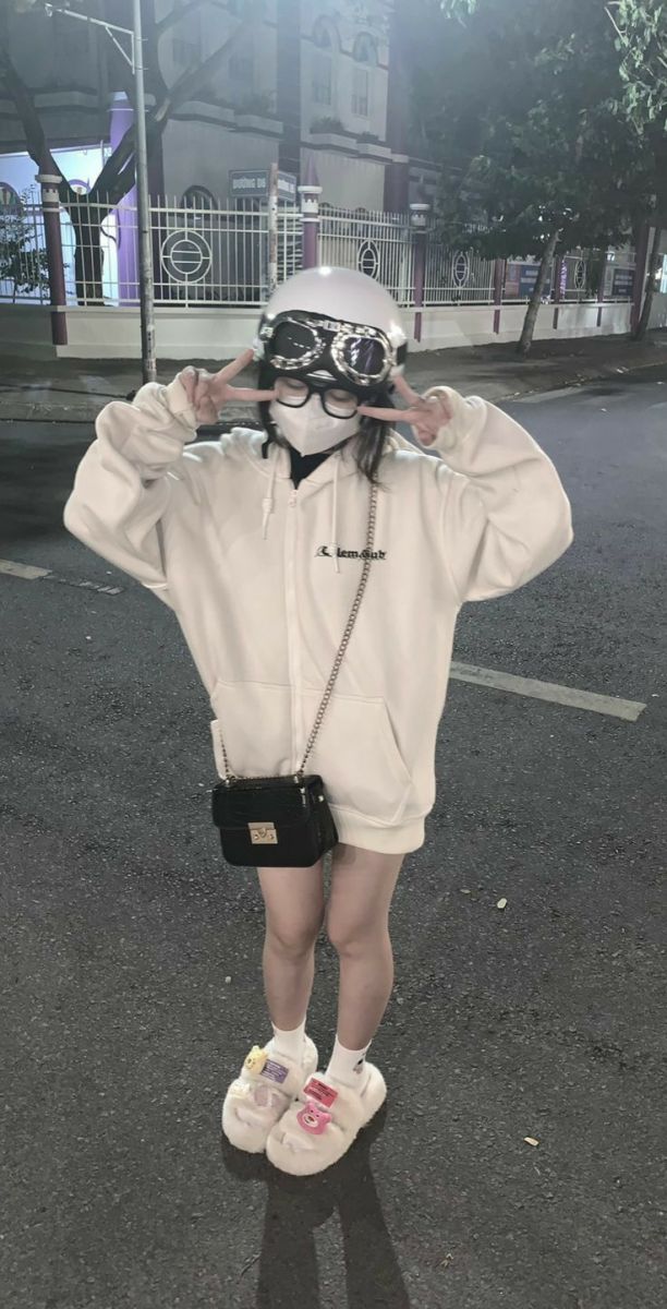 Gái xinh mặc áo hoodie trắng và quần ngắn tạo dáng trên phố