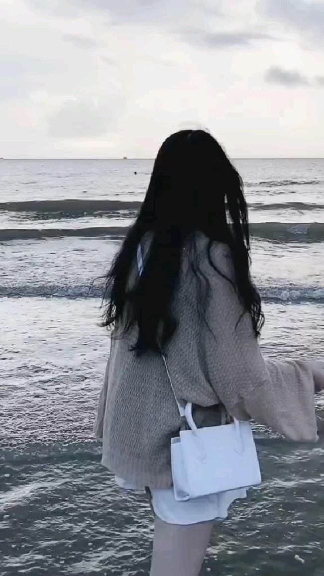 Gái xinh mặc áo len và quần short bên bãi biển
