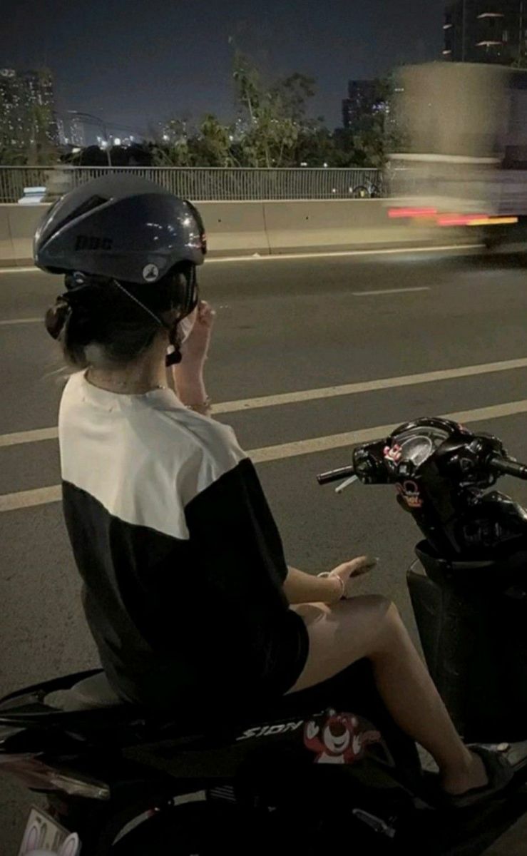 Gái xinh mặc áo phông đen trắng trên xe máy giữa phố