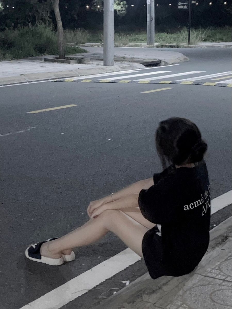 Gái xinh mặc áo phông rộng bên đường ô tô vào buổi tối
