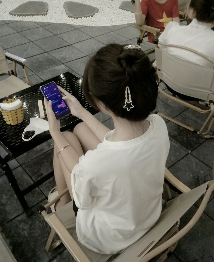 Gái xinh mặc áo phông trắng ngồi trong quán cà phê
