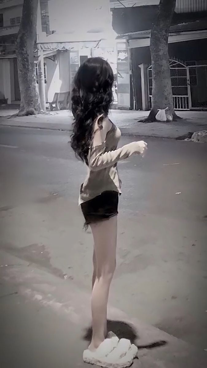 Gái xinh mặc áo sát nách và chân váy ngắn bên đường