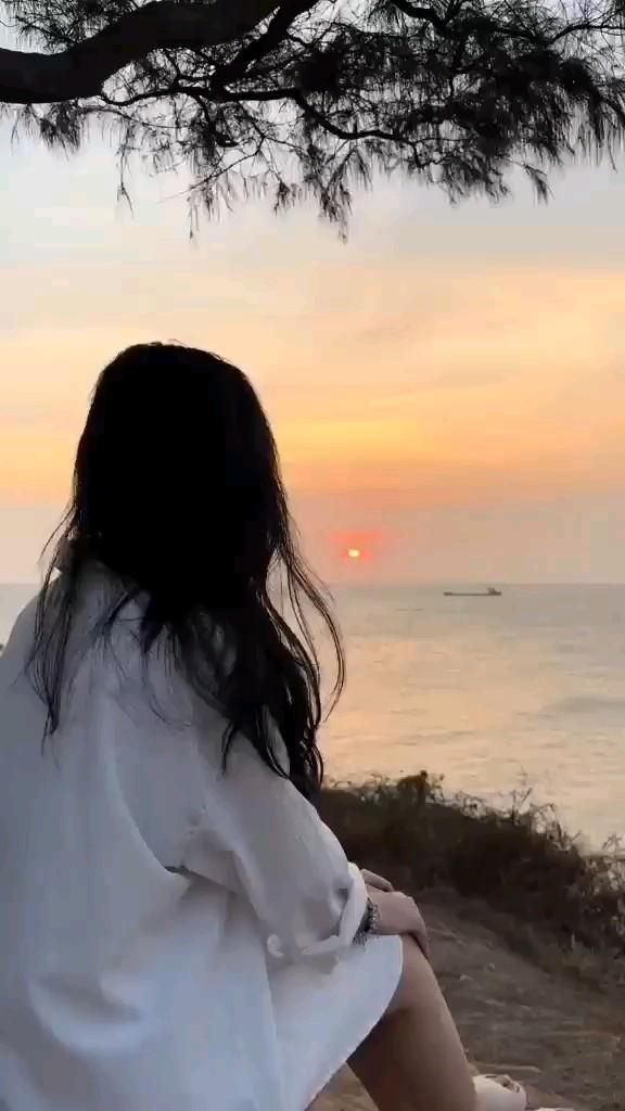 Gái xinh mặc áo sơ mi trắng ngắm hoàng hôn trên biển