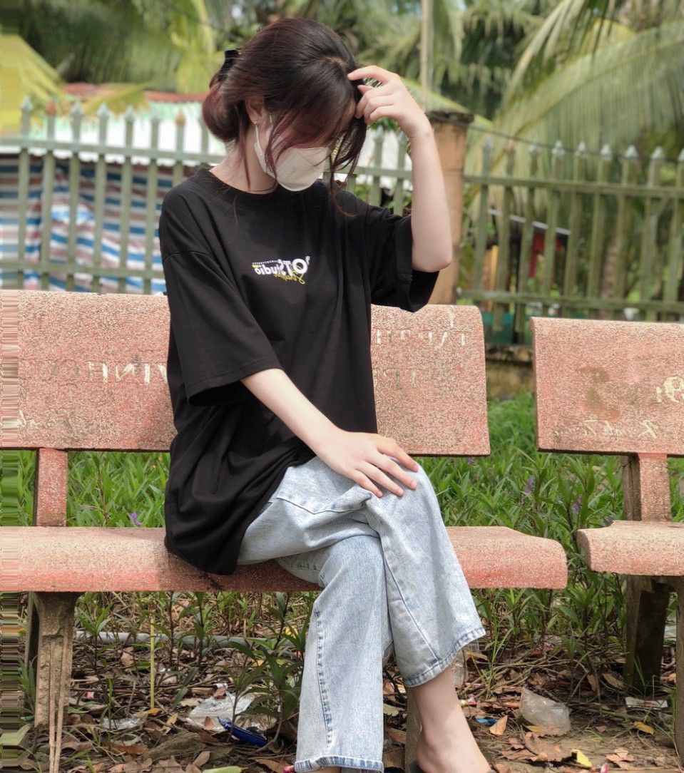 Gái xinh mặc áo thun đen và quần jeans sáng màu trong công viên