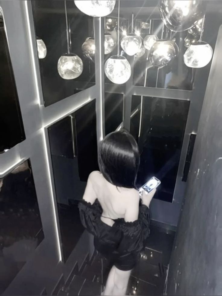 Gái xinh mặc áo trễ vai màu đen trong không gian tối