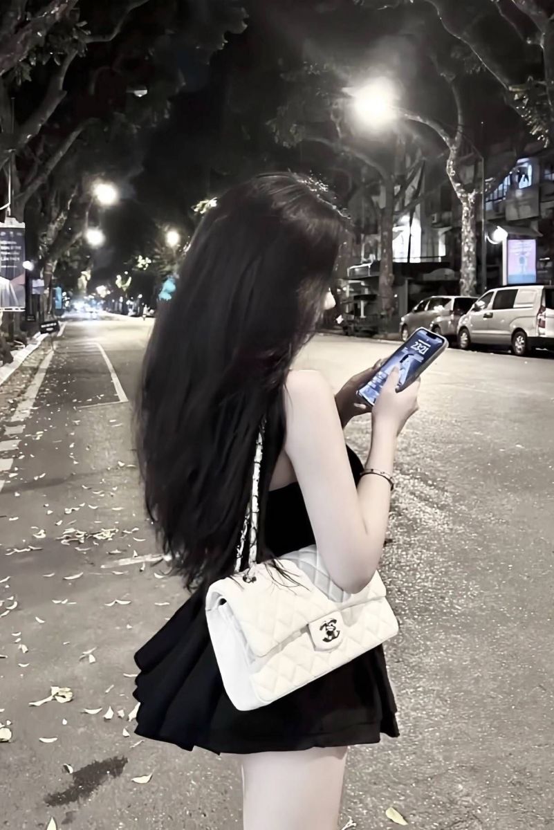 Gái xinh mặc váy đen dừng trên đường phố vào ban đêm