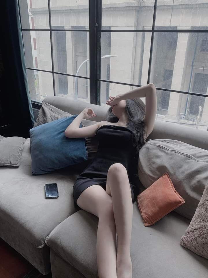 Gái xinh mặc váy đen nằm trên sofa duyên dáng