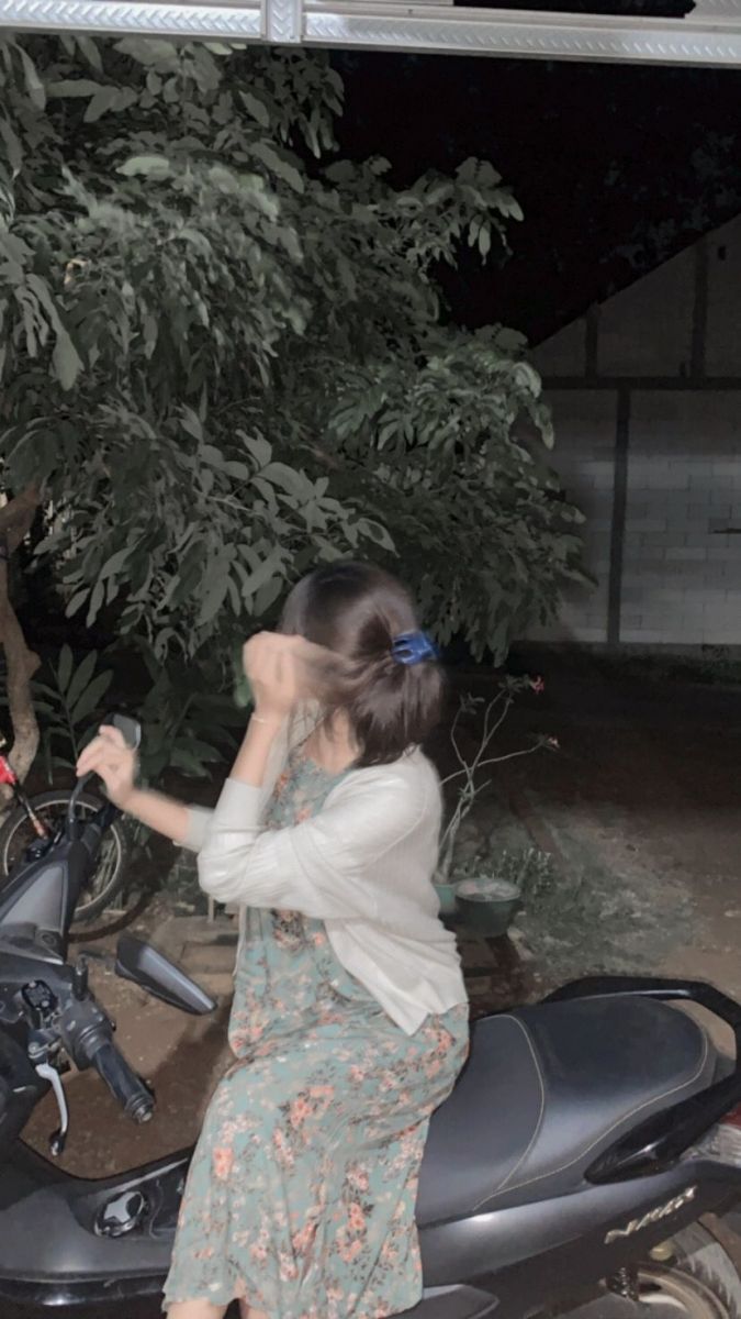 Gái xinh mặc váy hoa ngồi trên xe máy
