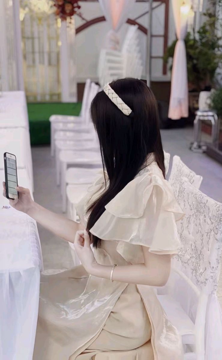 Gái xinh mặc váy kèm ngồi trên ghế sử dụng điện thoại