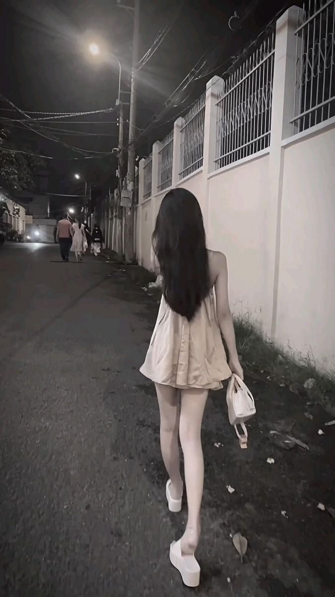 Gái xinh mặc váy ngắn đi bộ trên đường phố ban đêm