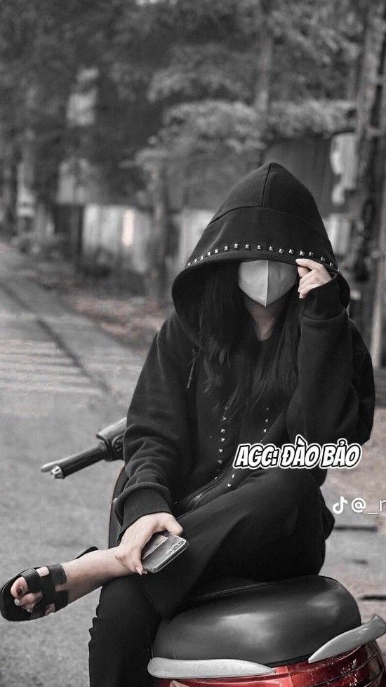 Gái xinh ngồi trên xe máy cầm điện thoại giữa phố vàng