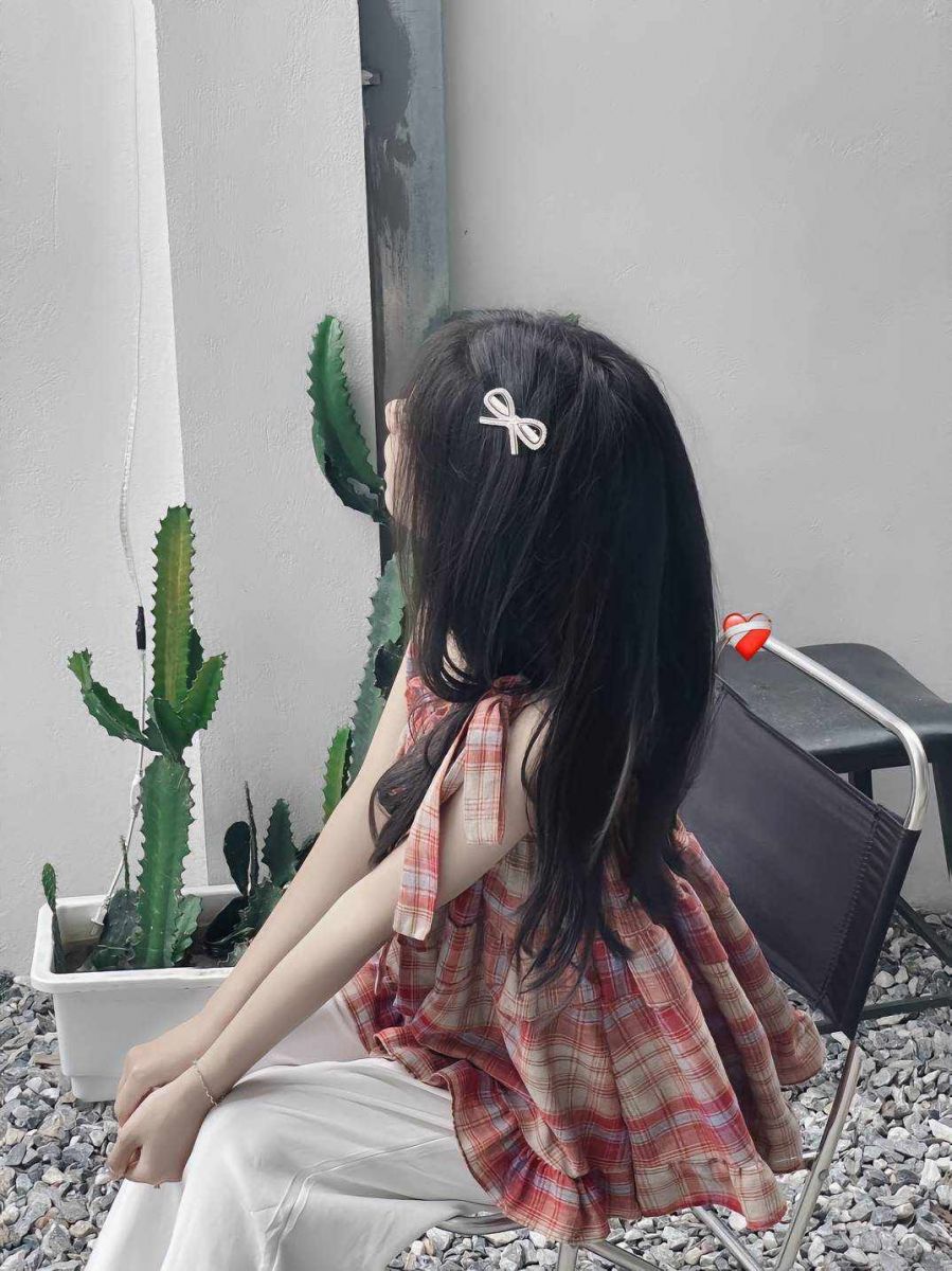 Gái xinh trong áo blouse trắng ngồi tựa lưng vào tường