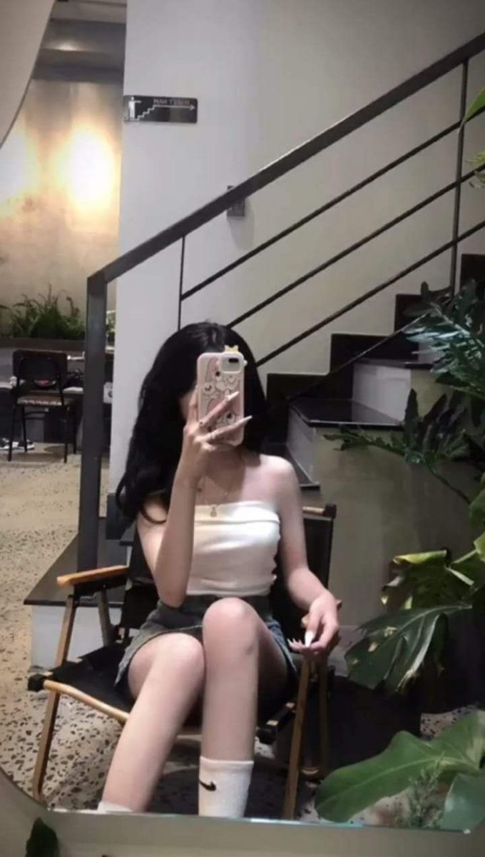 Gái xinh trong áo crop top và chân váy ngắn chụp selfie tại quán cà phê