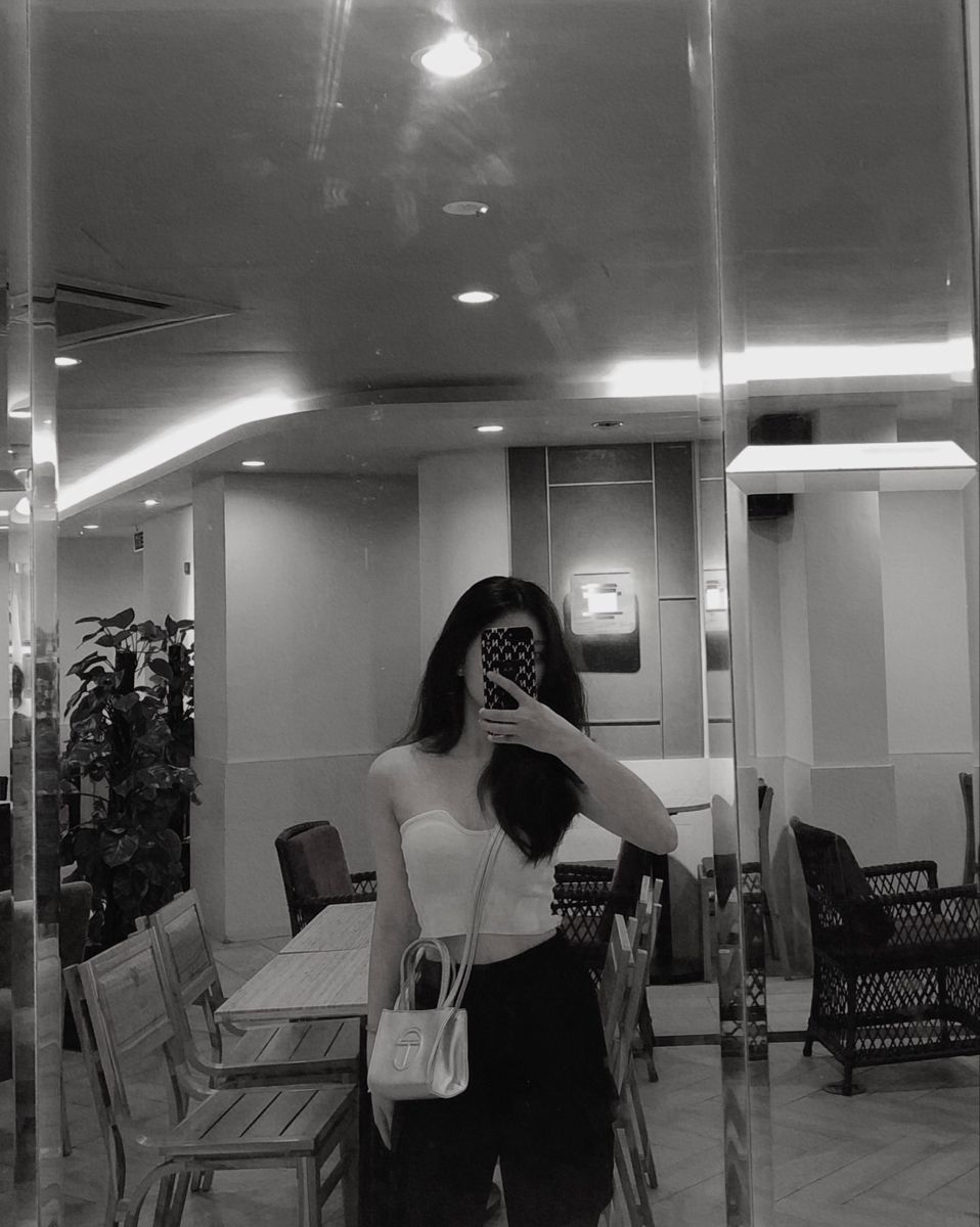Gái xinh trong áo croptop trắng và quần đen tại quán cà phê