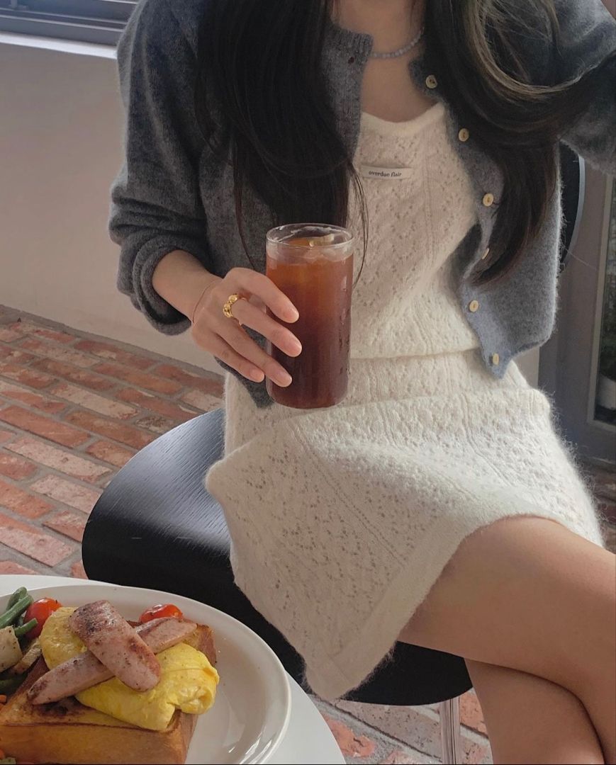 Gái xinh trong áo khoác cardigan xám và váy trắng ngồi thưởng trà