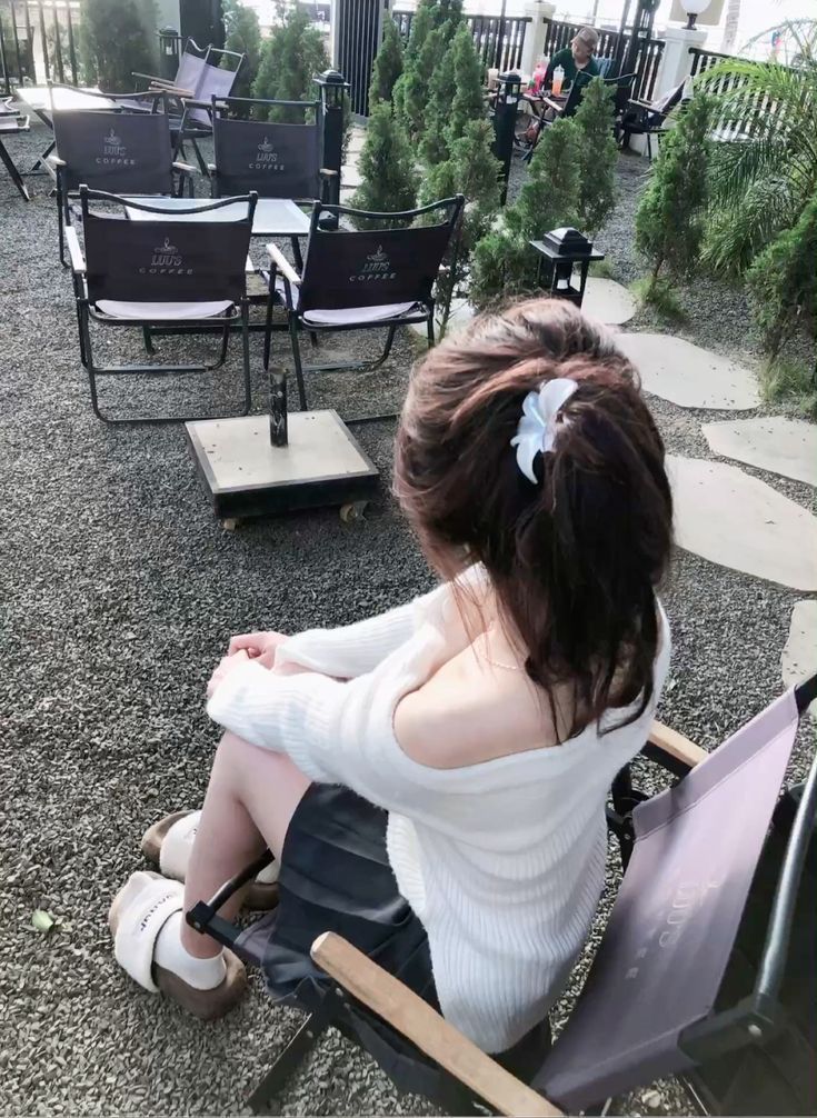 Gái xinh trong áo len trắng và chân váy đen tại quán cà phê