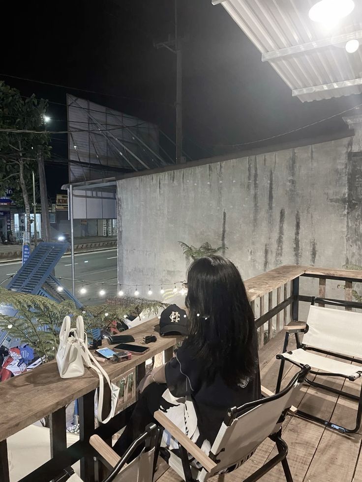 Gái xinh trong áo phông đen và quần dài tại quán cà phê