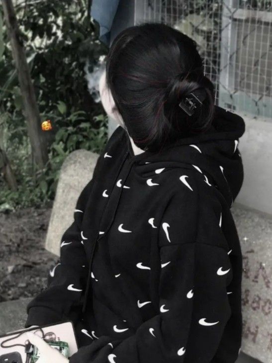 Gái xinh trong hoodie đen ngồi giữa thiên nhiên