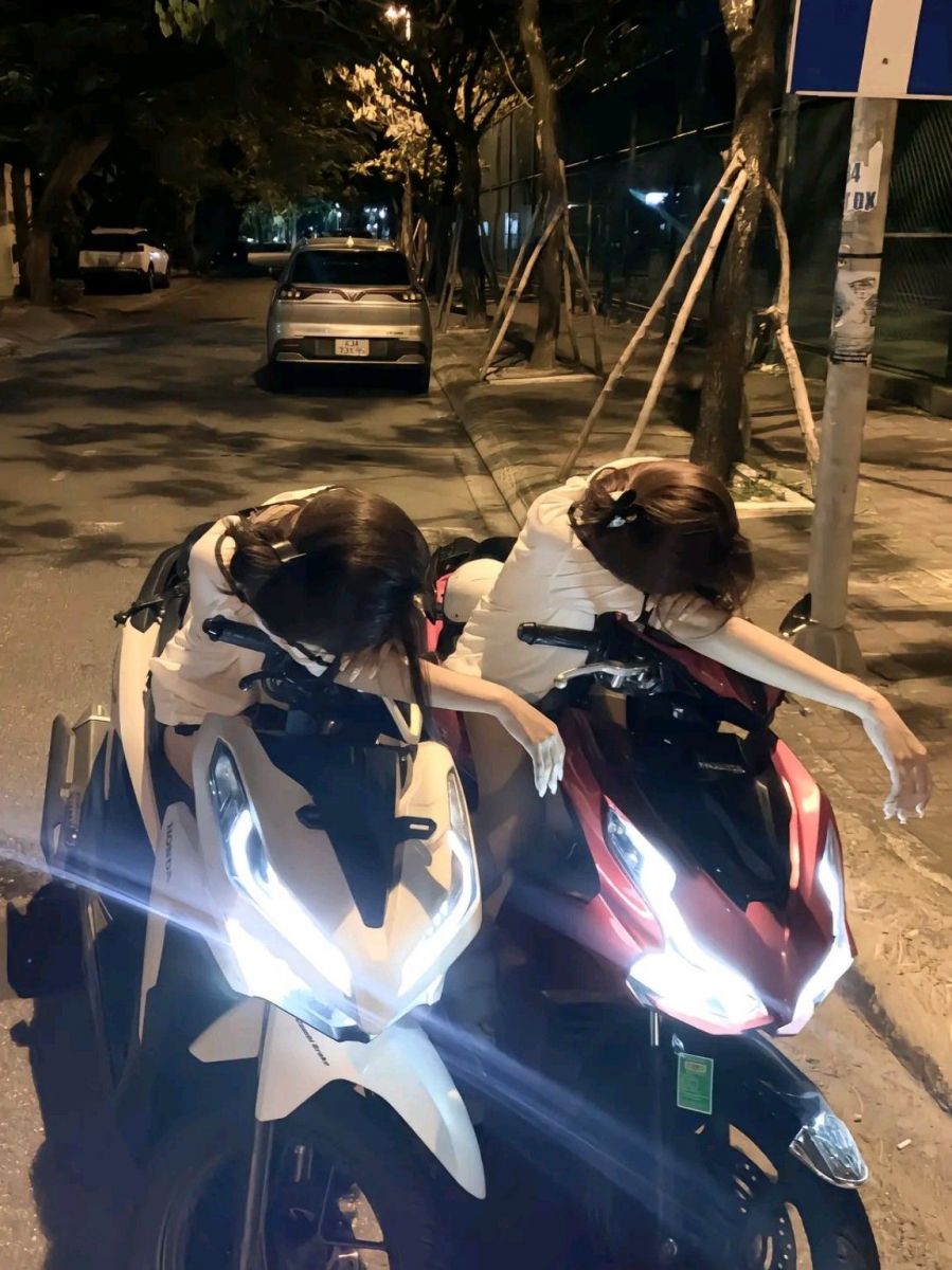 Hai cô gái xinh đẹp không mặc áo trên xe máy giữa phố