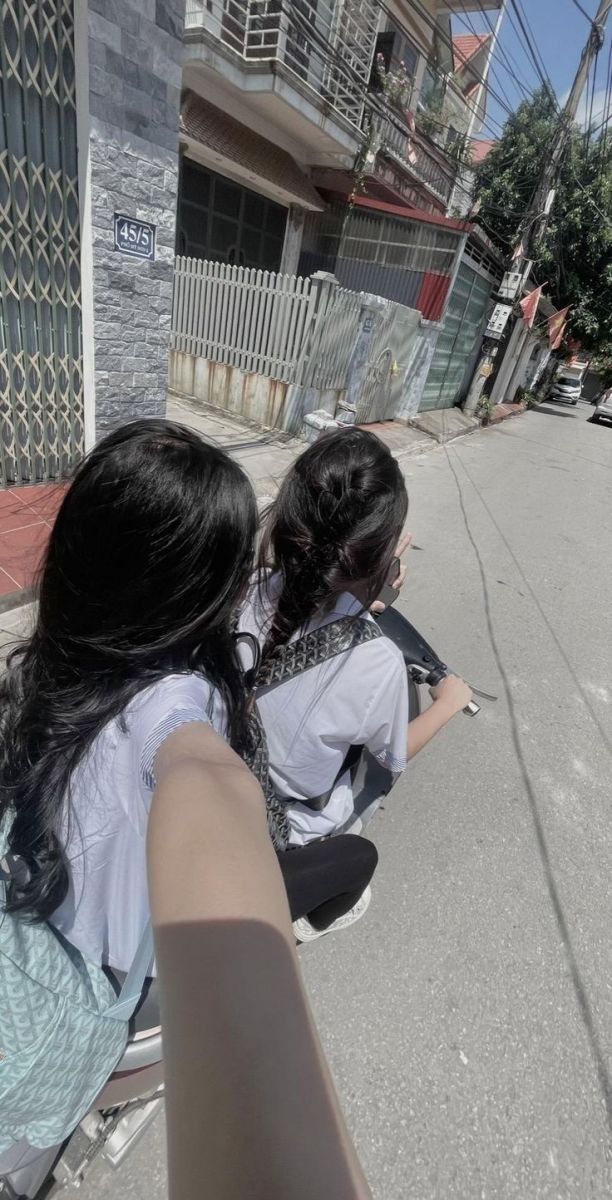Hai cô gái xinh đẹp ngồi trên xe máy