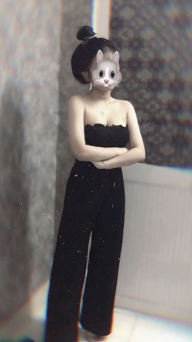 Nữ mặc jumpsuit đen với tay khoanh trước ngực