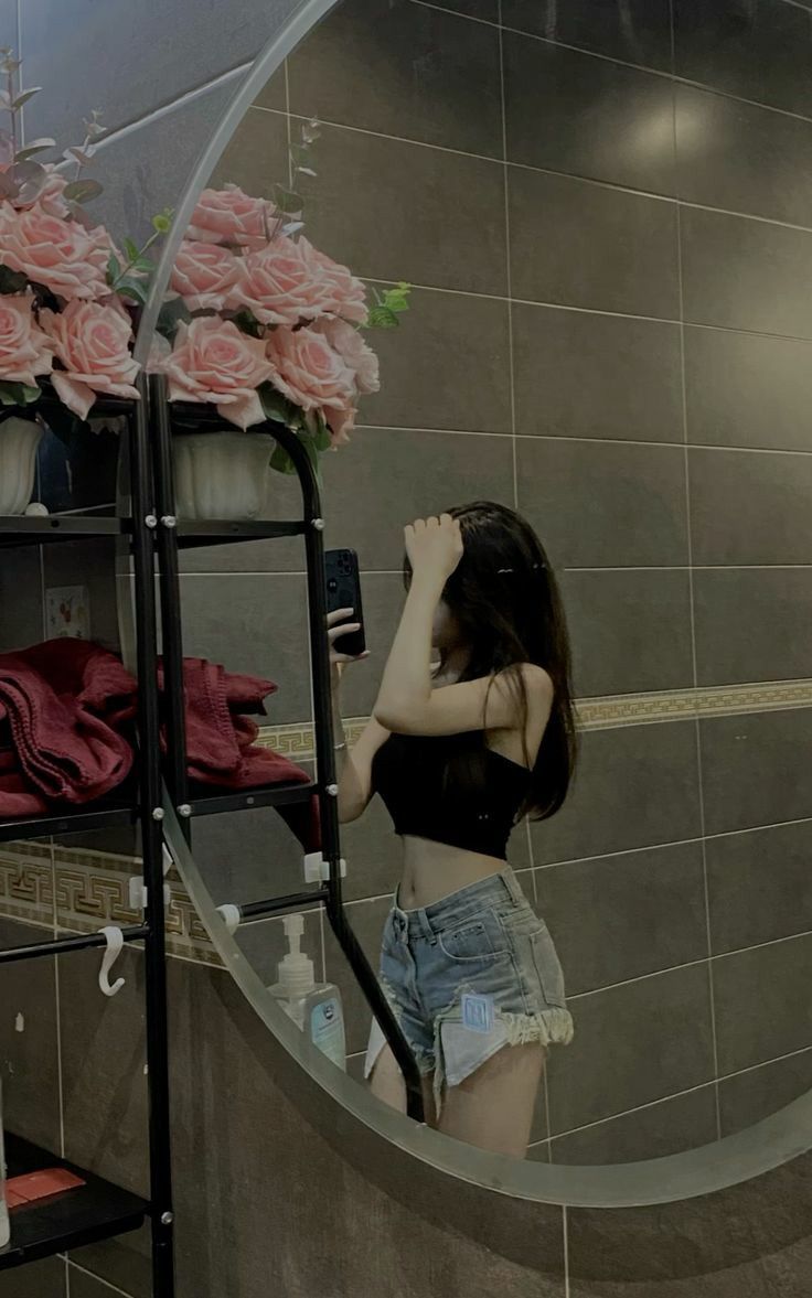 Ảnh cô gái trẻ mặc áo crop top đen và quần short jeans