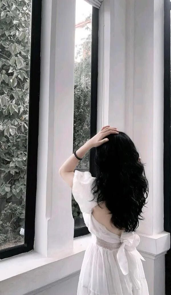 Ảnh gái mặc váy trắng bên cửa sổ, nhìn ra cây cối xanh rì