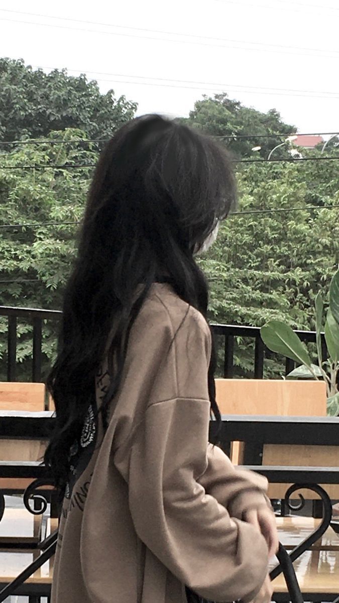 Ảnh gái trẻ mặc áo oversized màu nâu bên cửa sổ quán cà phê