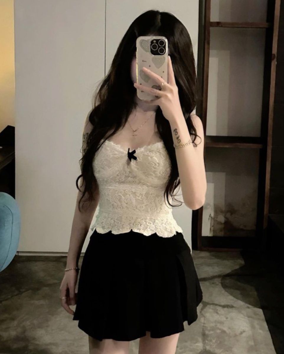 Ảnh gái trẻ mặc áo ren trắng và chân váy đen chụp selfie trong phòng