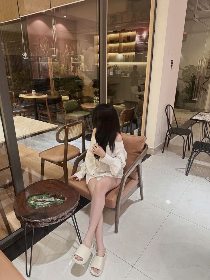 Ảnh gái trẻ mặc áo sơ mi trắng ngồi trên ghế sofa