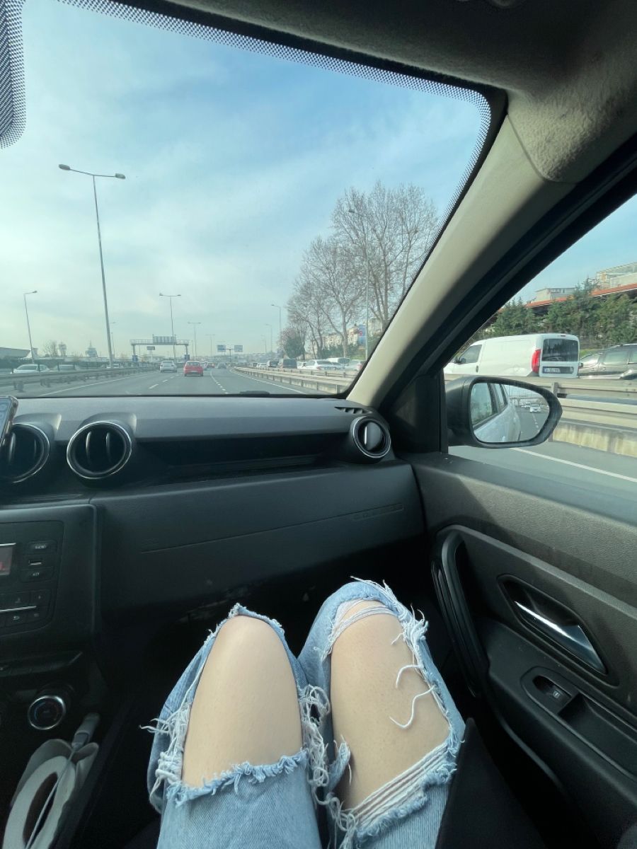 Ảnh gái trẻ mặc quần jeans rách ngồi trong ô tô