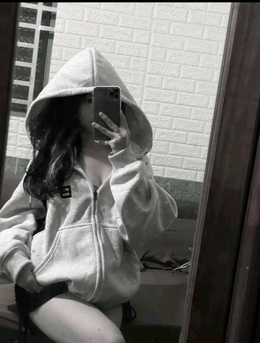 Ảnh gái trong áo hoodie xám chụp selfie trên giường