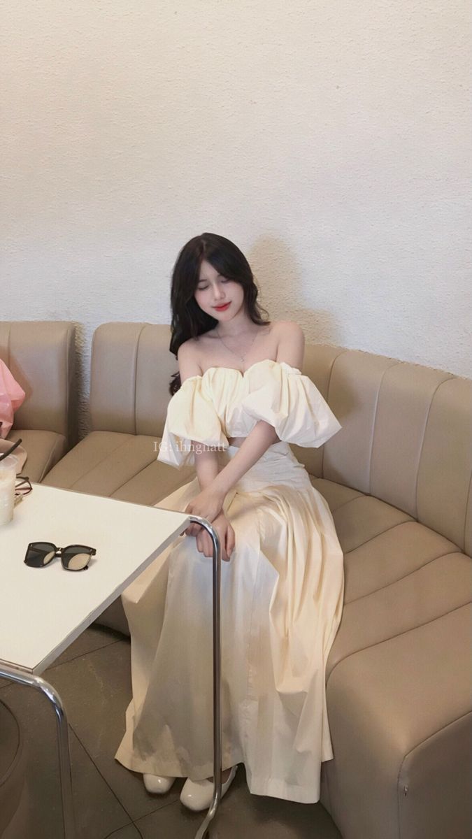 Ảnh gái xinh mặc váy trắng ngồi trên ghế sofa trong quán cà phê