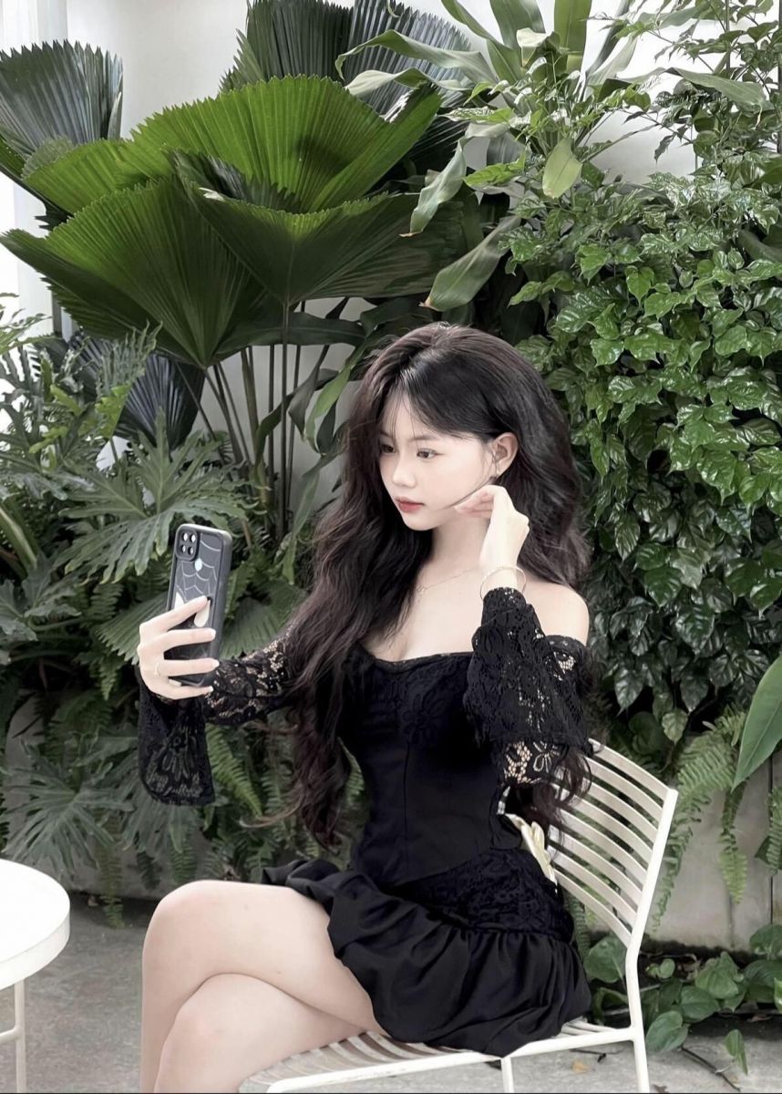 Cô gái đẹp mặc váy đen chụp selfie giữa thiên nhiên xanh mát