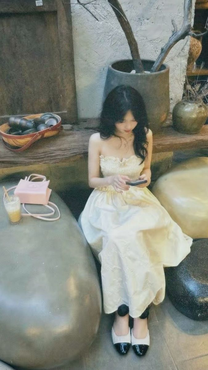 Cô gái đẹp mặc váy trắng ngồi trong quán cafe