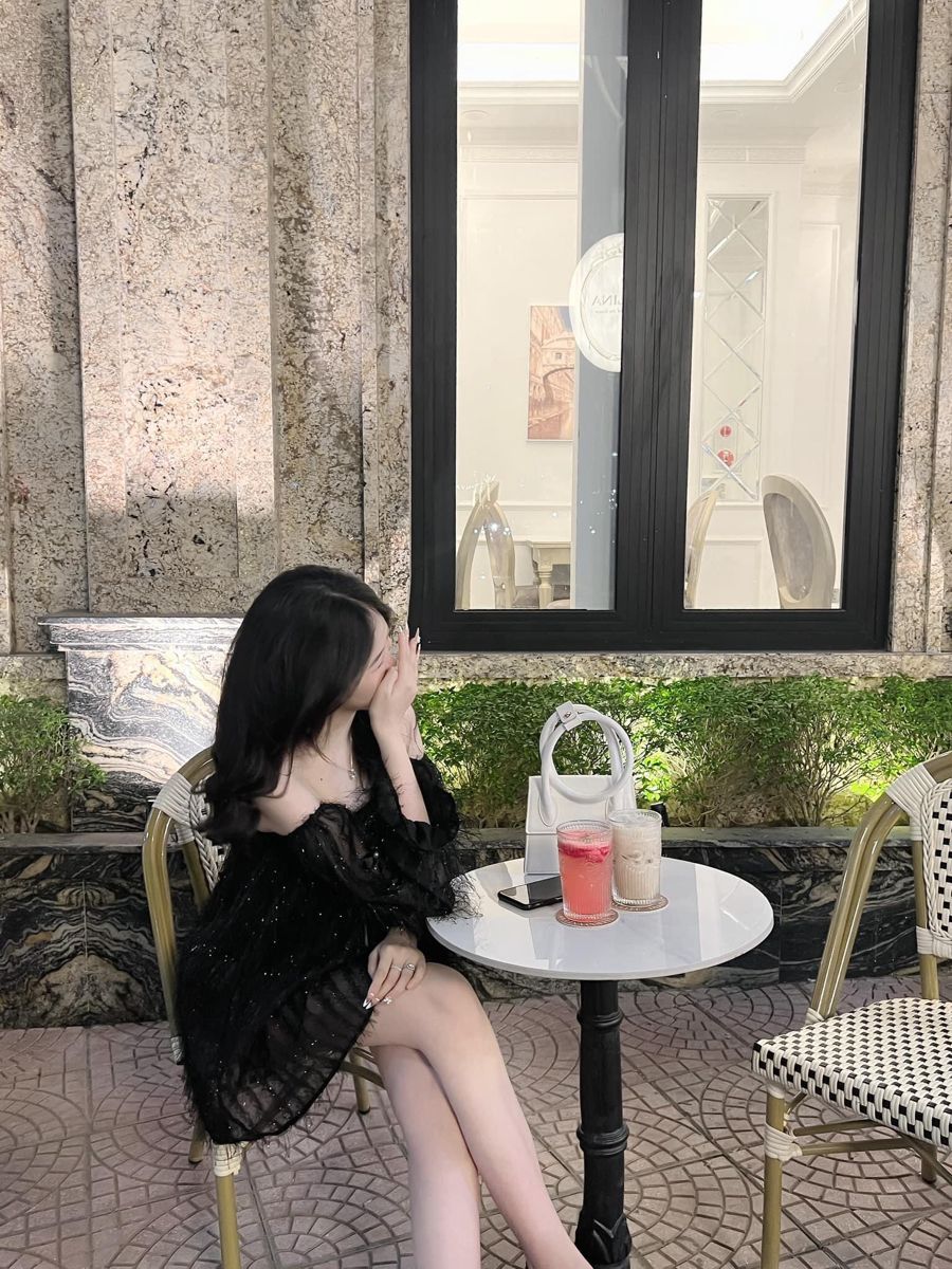 Cô gái đẹp trong chiếc váy đen xuyên thấu bên bàn trà