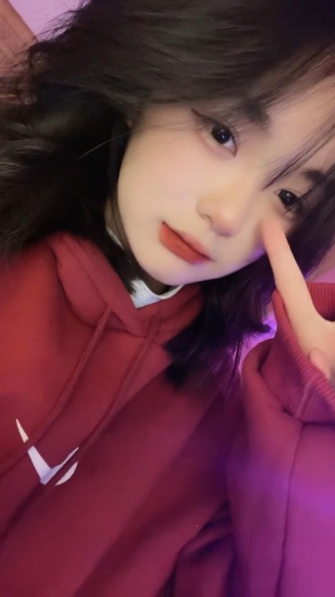 Cô gái mặc áo hoodie đỏ tạo dáng chụp ảnh trong không gian nội thất
