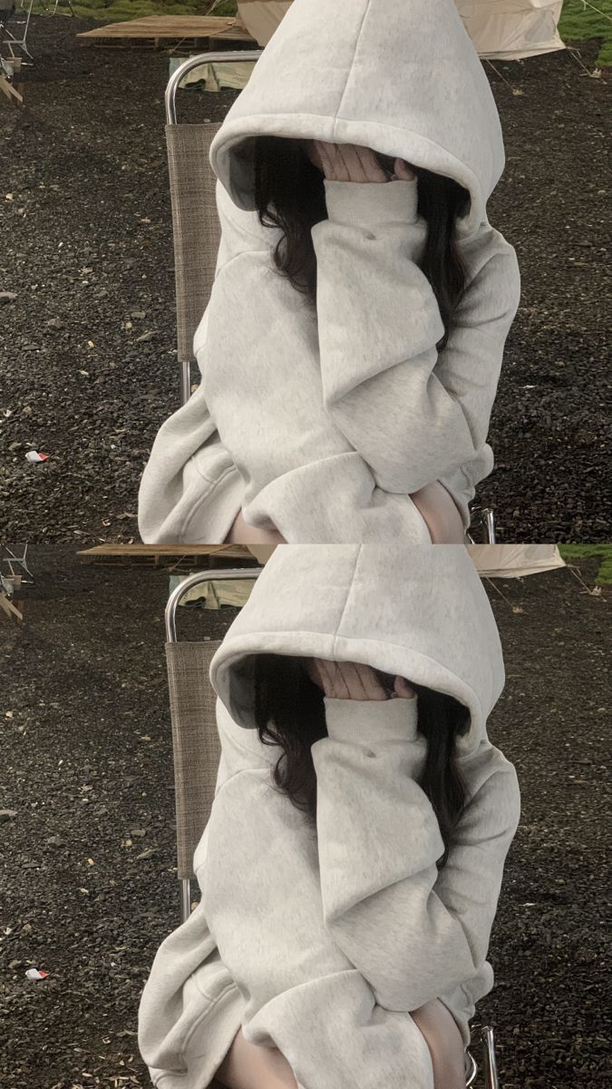 Cô gái mặc áo hoodie xám che mặt trong khung cảnh ngoài trời