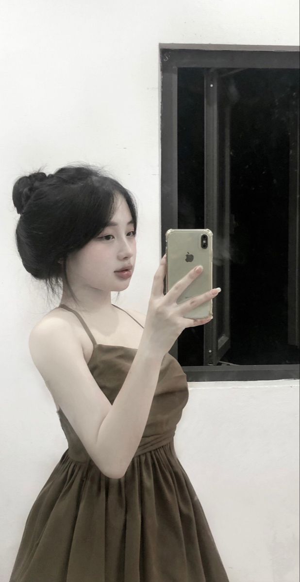 Cô gái mặc đầm màu nâu chụp ảnh selfie trong phòng sáng tạo