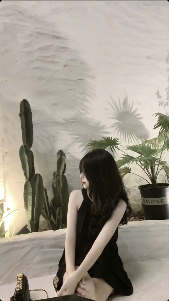 Cô gái mặc trang phục đen giữa không gian xanh tươi