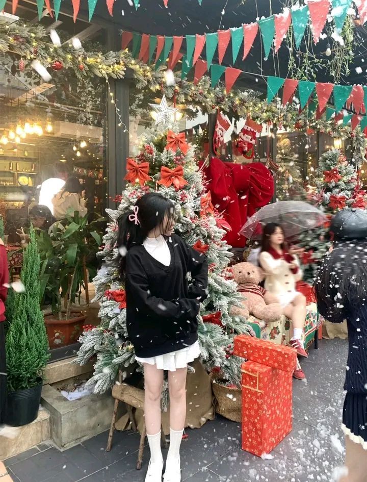 Cô gái trẻ mặc áo len bên cây thông Noel xinh đẹp