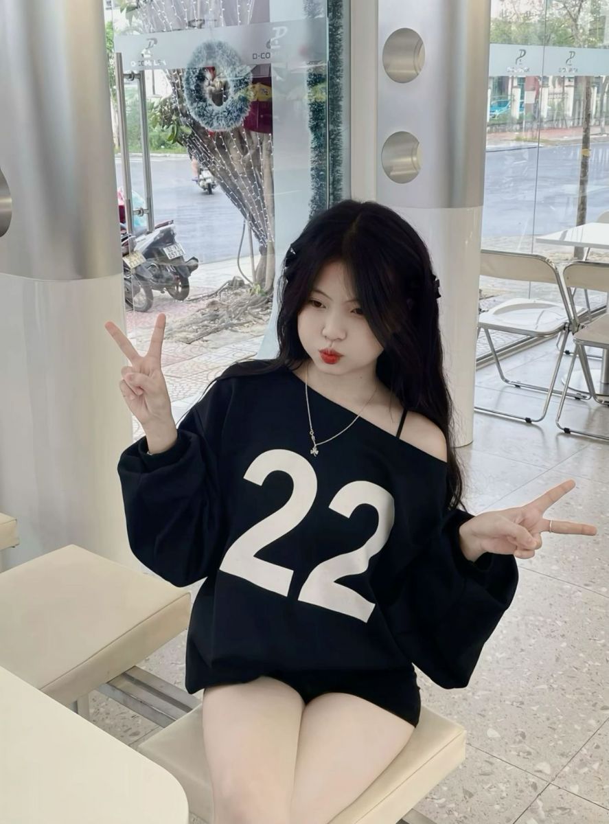 Cô gái trẻ mặc áo oversized màu đen tỏa sáng giữa không gian