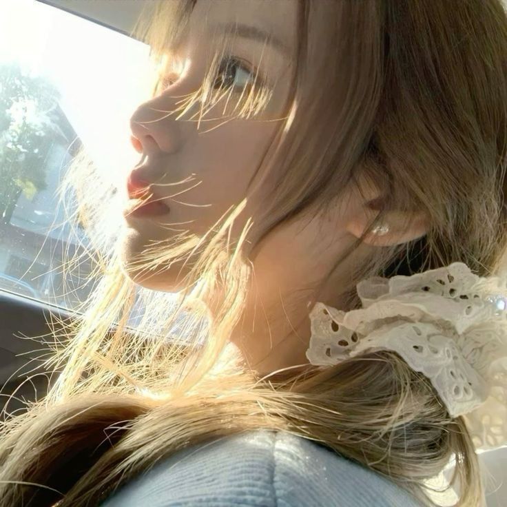 Cô gái trẻ mặc áo sweater ngồi trong xe hơi